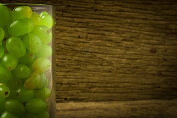 grapes green in glass  om old wood