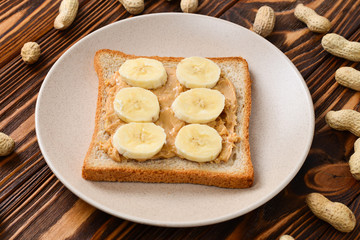 Peanut butter toast with banana slices  on wooden background