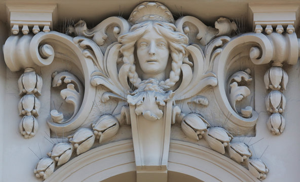 Architectural detail with a mascaron of a young woman set on top of a column on the facade of an old building, Zagreb, Croatia 