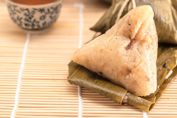 Zongzi - Traditional Dragon Boat Festival dumpling. Hand drawn watercolor painting isolated on wood background.