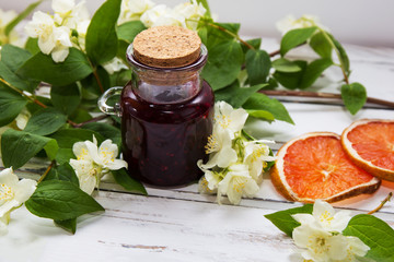 Jasmine dry green tea leaves with jasmine flowers and raspberry jam white background.