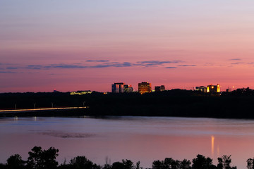 Obraz premium Zachód słońca nad Bloomington, Minnesota z rzeką Mississippi na pierwszym planie.