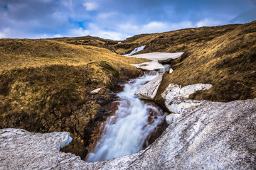 Fototapeta na wymiar Icelandic wilderness - May 08, 2018: Small waterfall in the icy wilderness of Iceland