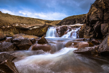 Icelandic wilderness - May 08, 2018: Small waterfall in the icy wilderness of Iceland
