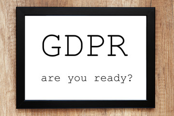 Top view of a desk with a black frame with the words "GDPR are you ready?"