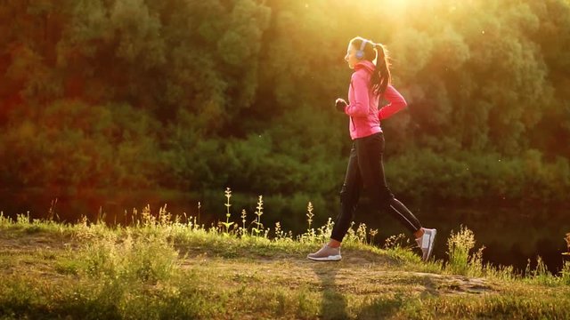 A morning jog in the Park near the pond in the Sunny rays of dawn, the girl is preparing to Mariano and lead a healthy lifestyle