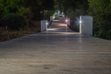Beleuchteter Holzsteg in der Nacht