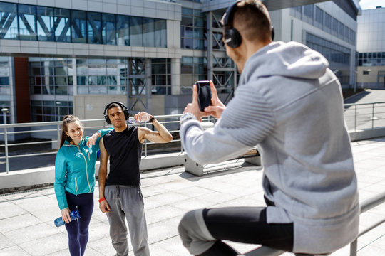 an athlete takes pictures of his friends after training on the street