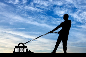 Silhouette of a man chained to a heavy load under the name of the credit