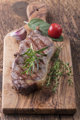 Gegrilltes Steak auf Holz mit Gewürzen