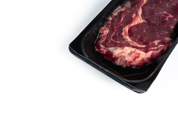 Raw steak in plastic pack.