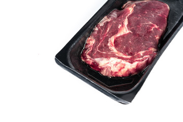 Raw steak in plastic pack.