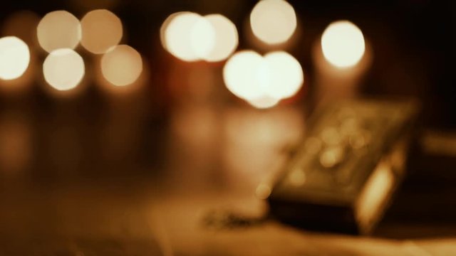 Antique Holy Bible and burning candles in the Church