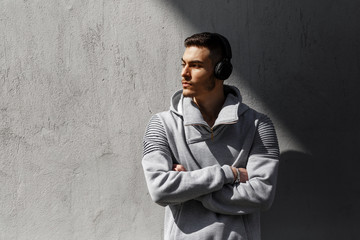 Portrait of young atractive fitness man with headphones outdoors