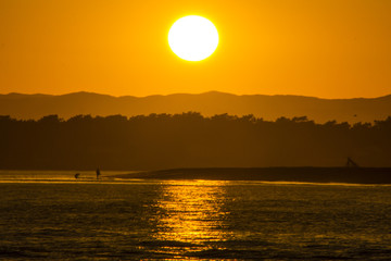 The sun goes down over the spanish border with Portugal at Isla Canela, Huelva