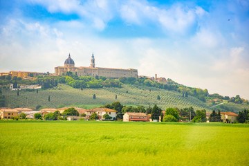 Fototapeta na wymiar Loreto, Basilica over summer fields in Italian province of Ancona, Italy