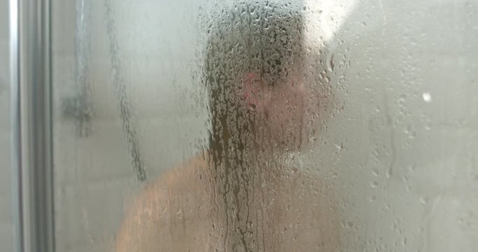 Pretty young woman taking a shower