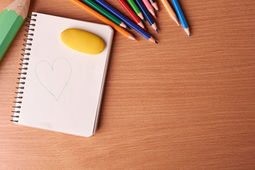 blank notebook page with colored pencils on table