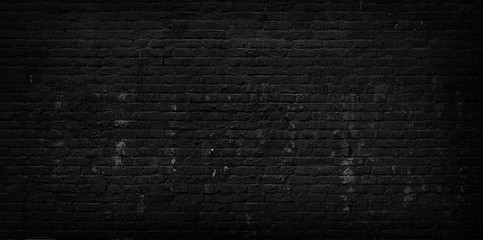 Old cracked black brick wall background.