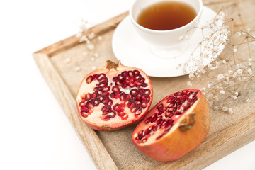 Fototapeta na wymiar Fresh and Healthy Antioxidant Pomegranate Tea in the White Cup with Fresh Pomegranate Fruit and Seeds.