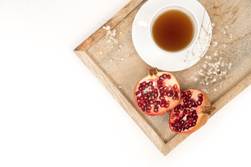 Fresh and Healthy Antioxidant Pomegranate Tea in the White Cup with Fresh Pomegranate Fruit and Seeds.