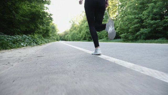 Legs, back running athlete. Shot with Steadicam, the movement for the running woman. Slow motion
