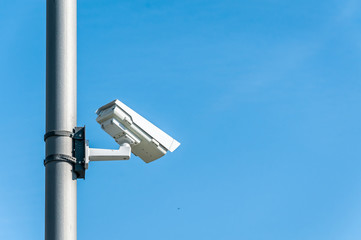 City cctv security surveillance camera system attached on the traffic light pole with clear blue...