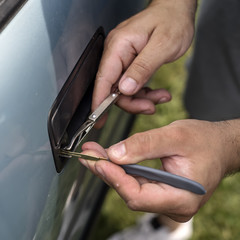 Male Mechanic Holding Lockpicker To Open Car Door