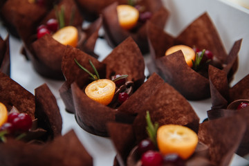 Chocolate cakes with orange and berries., muffins. Close Up of homemade Chocolate Muffins