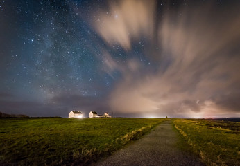 Milky way behind clouds over farm Skandinavia