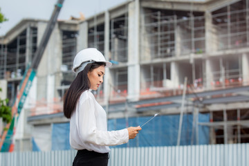 Fototapeta na wymiar Female engineer inspecting construction work in hand holding clipboard with document.