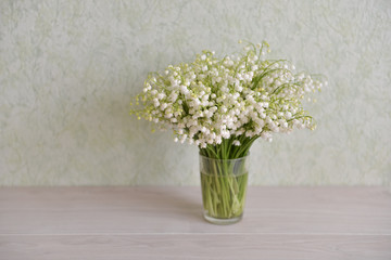 flowers lily of the valley stand on the table background