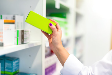 Woman customer in the pharmacy taking a medicine box