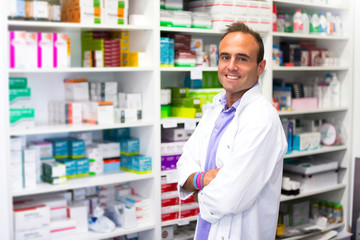 Happy adult man pharmacist in pharmacy