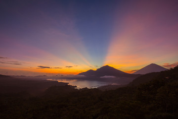 Obraz premium Scenic sunrise and mist at Agung volcano, Kintamani, Bali, Indonesia. Sunrise view of Agung volcano, nature landscape