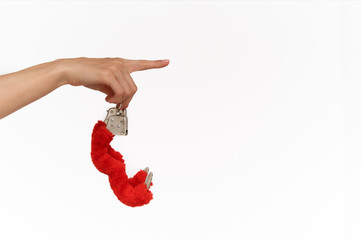 Female sexy hands in fur red handcuffs on a white background. Sex toys.