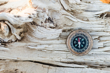 Compass on old wood texture background.