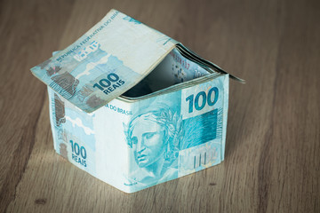 Home concept made from hundred Brazilian reais banknotes.