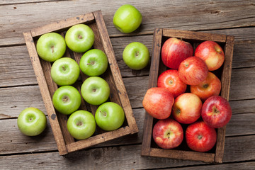 Green and red apples in wooden box