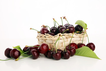 Cherry. Red fresh Cherries in basket and a bunch of cherries on the table
