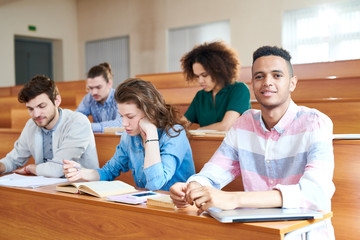 Group of students sitting at desk at lecture hall at university