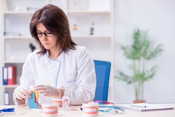 Woman dentist working on teeth implant