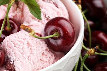 Homemade cherry ice cream and a bunch of cherries on table