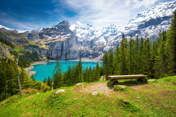 Amazing tourquise Oeschinnensee lake with waterfalls, wooden chalet and Swiss Alps, Berner...
