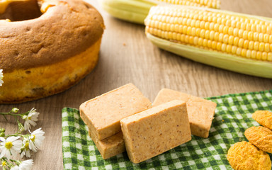 Pacoca is a candy with peanuts from Brazil. Sweet food of Festa Junina, a typical brazilian party. Snack on wood table and plaid fabric.