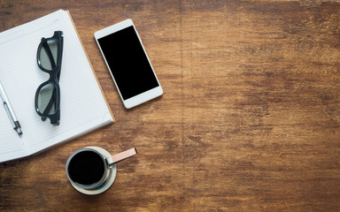 Coffee with blank notebook, glasses and phone with black blank space, flat lay