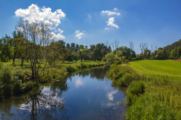 Fototapeta na wymiar A beautiful summer landscape / A small river among meadows and fields