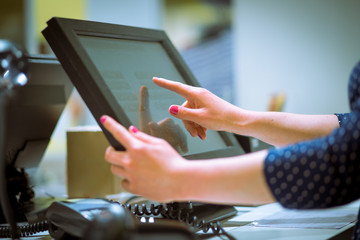 Saleswoman doing process payment on touchscreen pos, counting sale