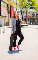 Fototapeta premium Young skater happy teen girl using a smart phone