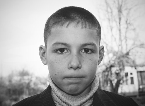 portrait of 8 years old boy with serious face and tightly clenched lips black and white photo